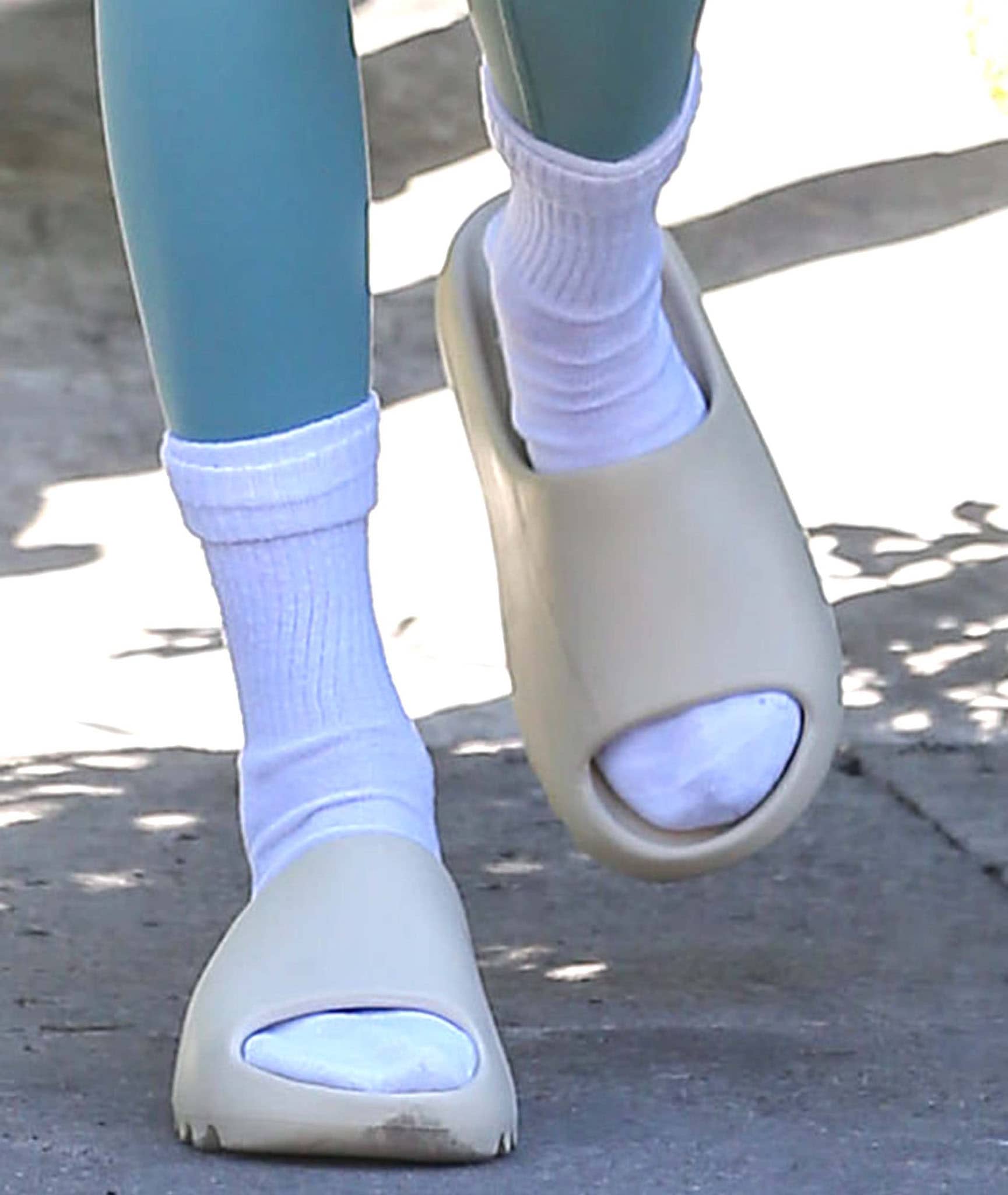 Kendall Jenner wears white socks with Yeezy slides in bone colorway