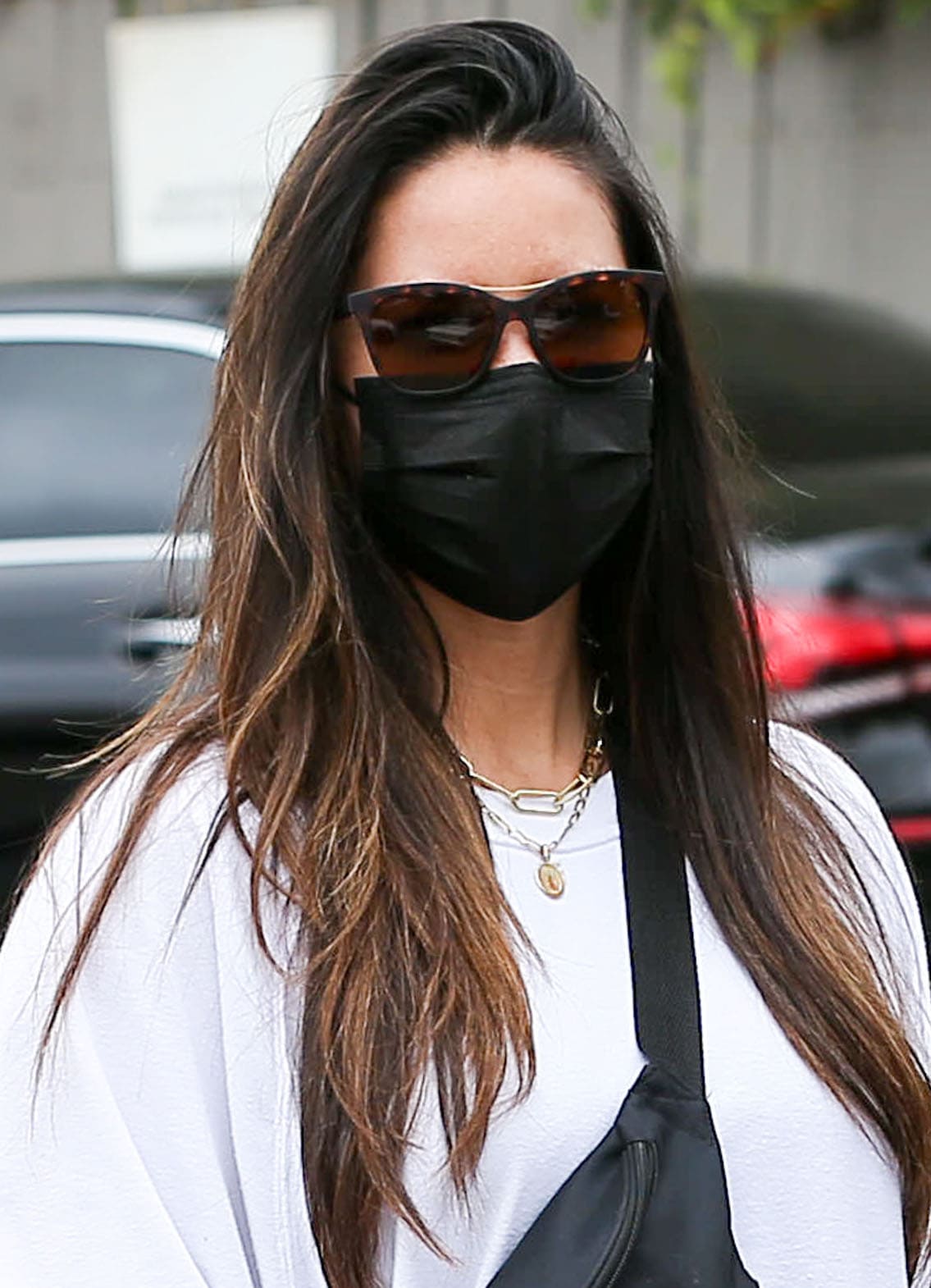 Olivia Munn wears a side-swept hairstyle and covers her eyes with Smith tortoiseshell sunglasses