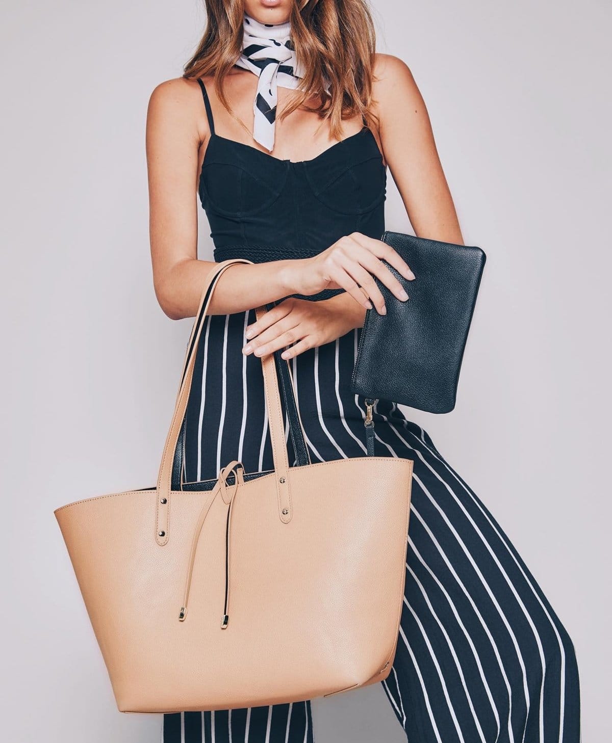 This reversible tote features a removable wristlet containing a 3000 mAh phone charging battery