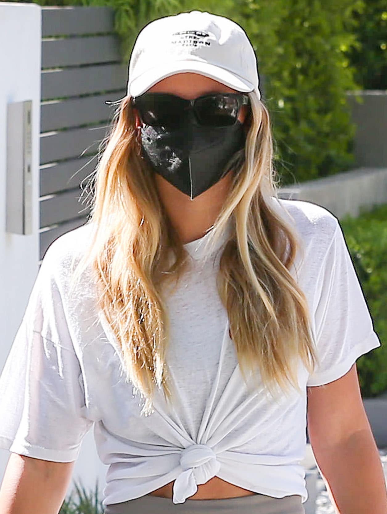 Sofia Richie keeps the sporty vibe of her look with a white The Madison Club baseball cap