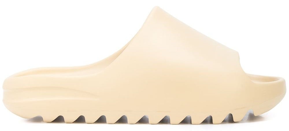 The Yeezy slide has a distinct silhouette with a shark-tooth rubber sole and a chunky upper