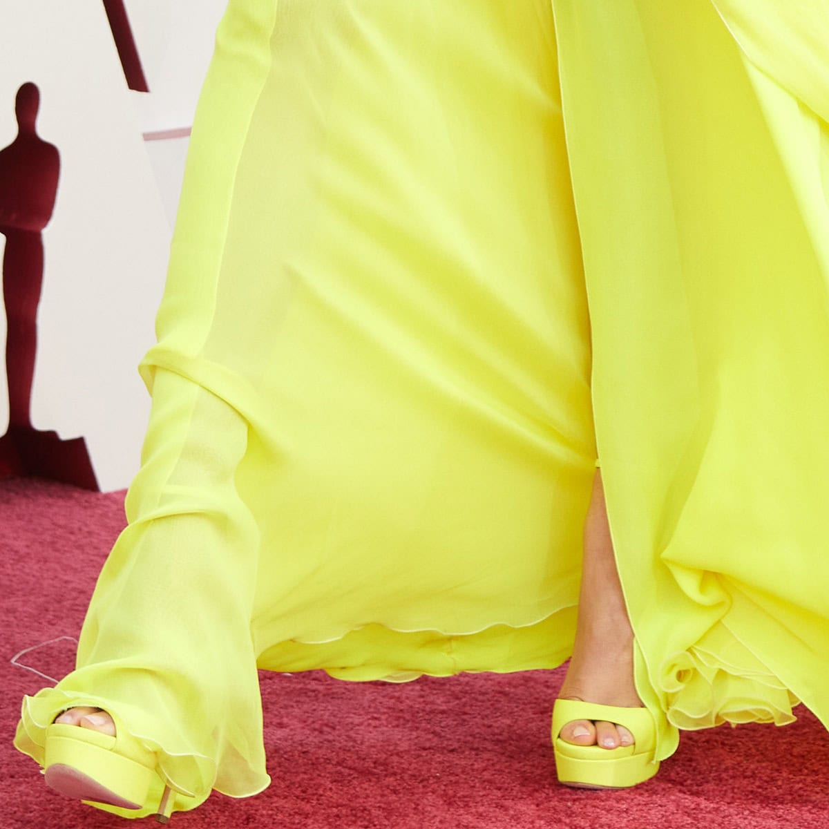 Zendaya's neon yellow platform heels perfectly matched her Valentino gown, while her glossy nude pedicure added a polished touch to the bold red carpet look