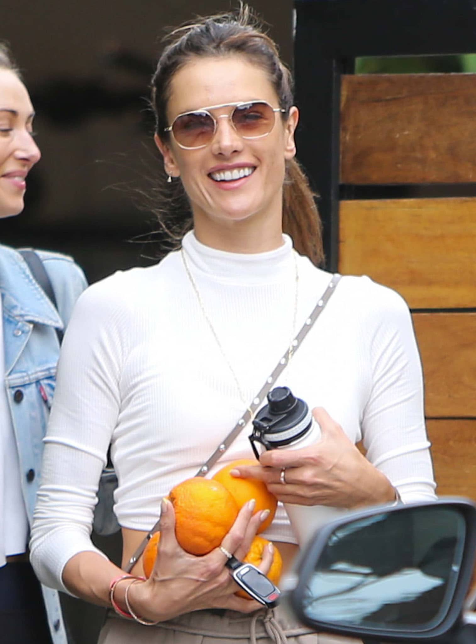 Alessandra Ambrosio flashes her pearly whites and shields her eyes behind a pair of Vehla Artesia sunnies