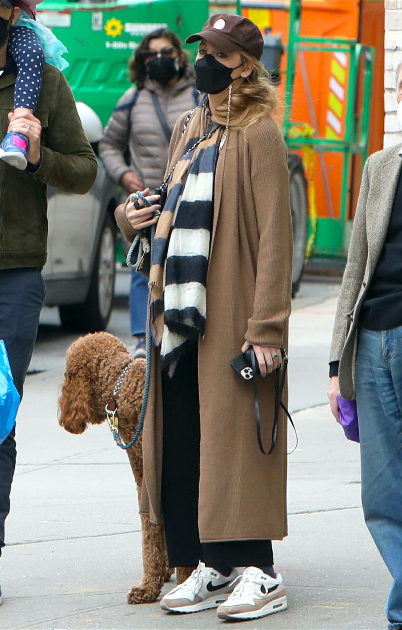 Blake Lively bundles up in an ankle-length cardigan with a striped scarf and loose-fitting black pants