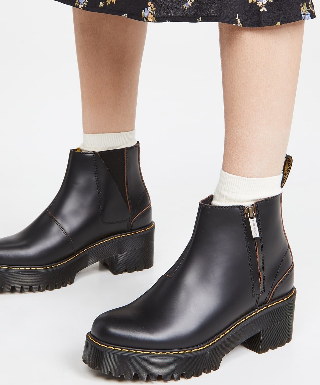 These black Dr. Martens boots feature a stacked platform and the label's signature yellow stitching