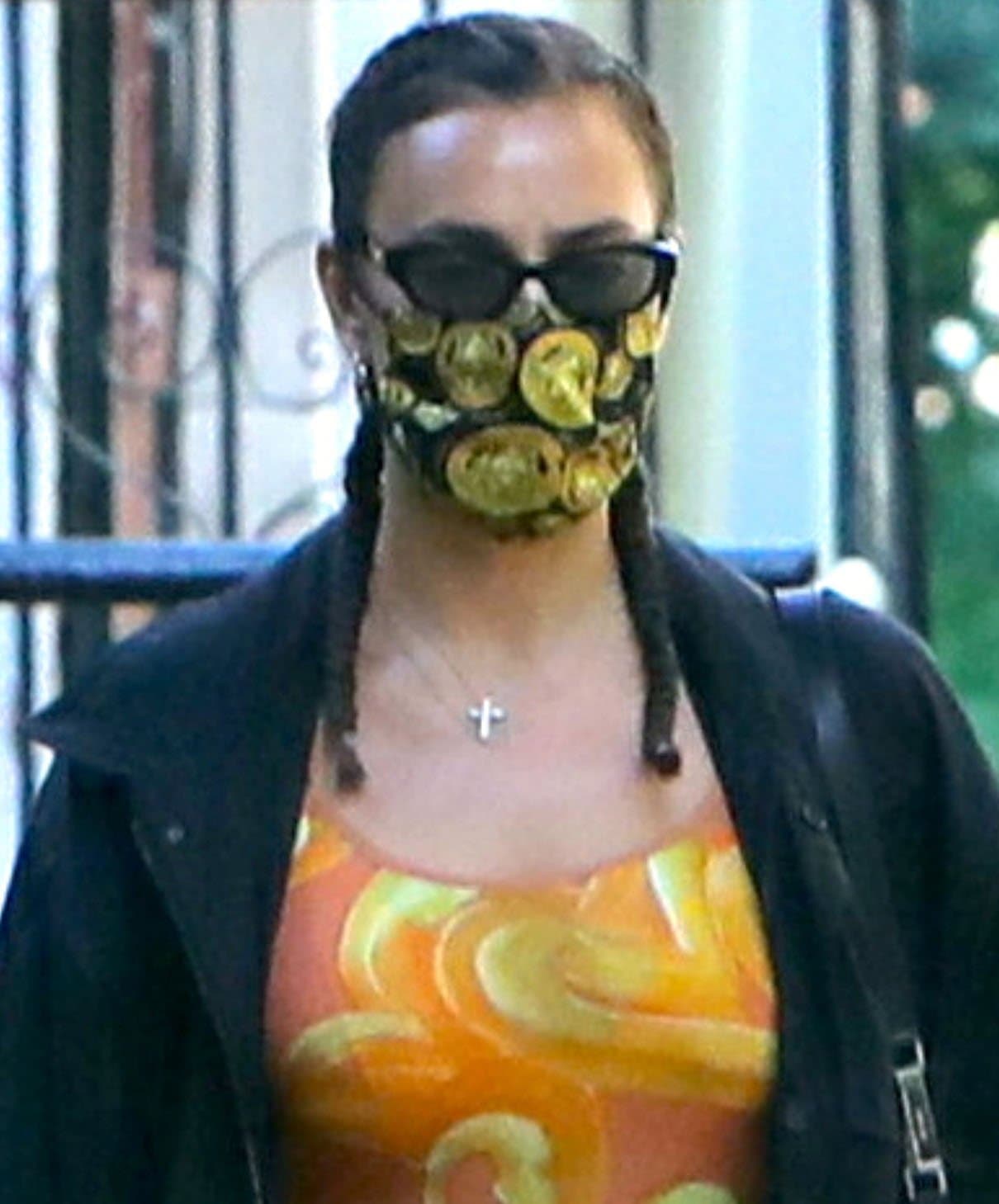 Irina Shayk wears cornrows with braided pigtails and hides her face underneath her Poppy Lissiman sunnies and Versace face mask