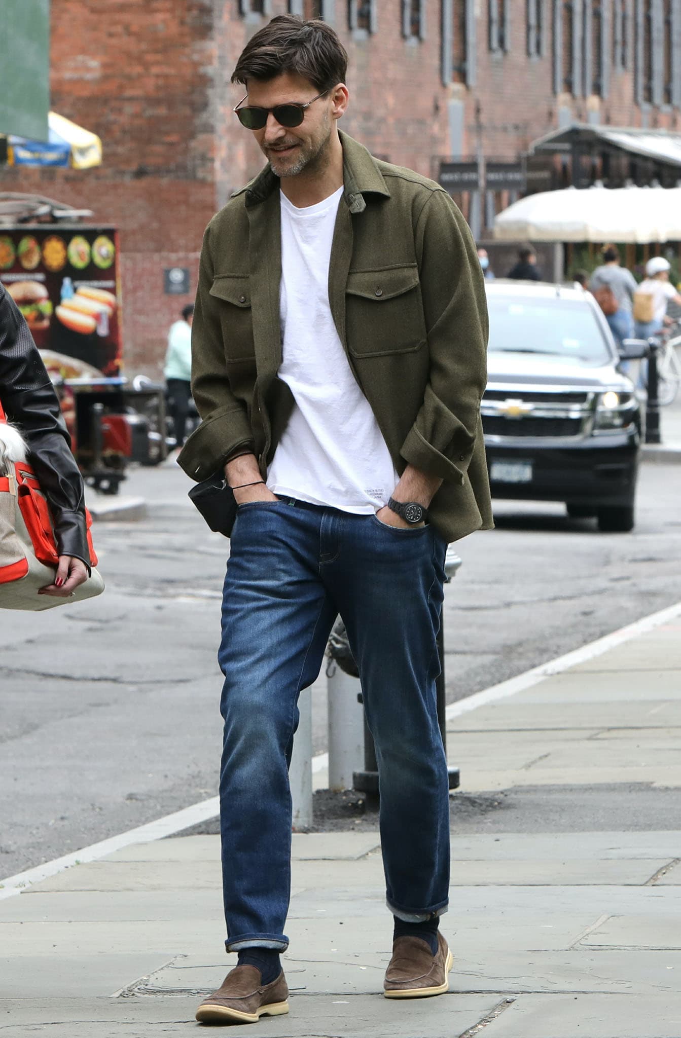 Johannes Huebl looks dapper in a white tee with blue jeans and an army green jacket