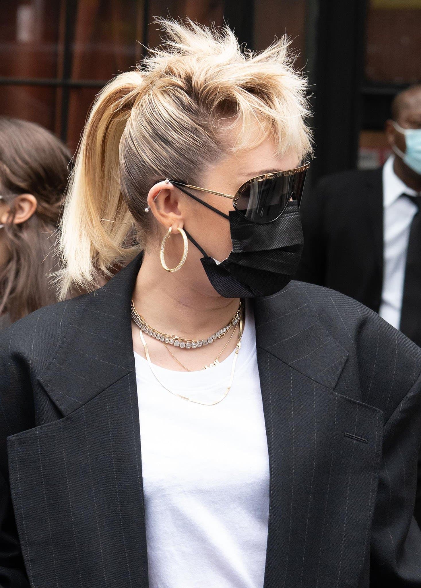 Miley Cyrus pulls her blonde hair into a mohawk ponytail and wears Dior Vintage '80s sunglasses