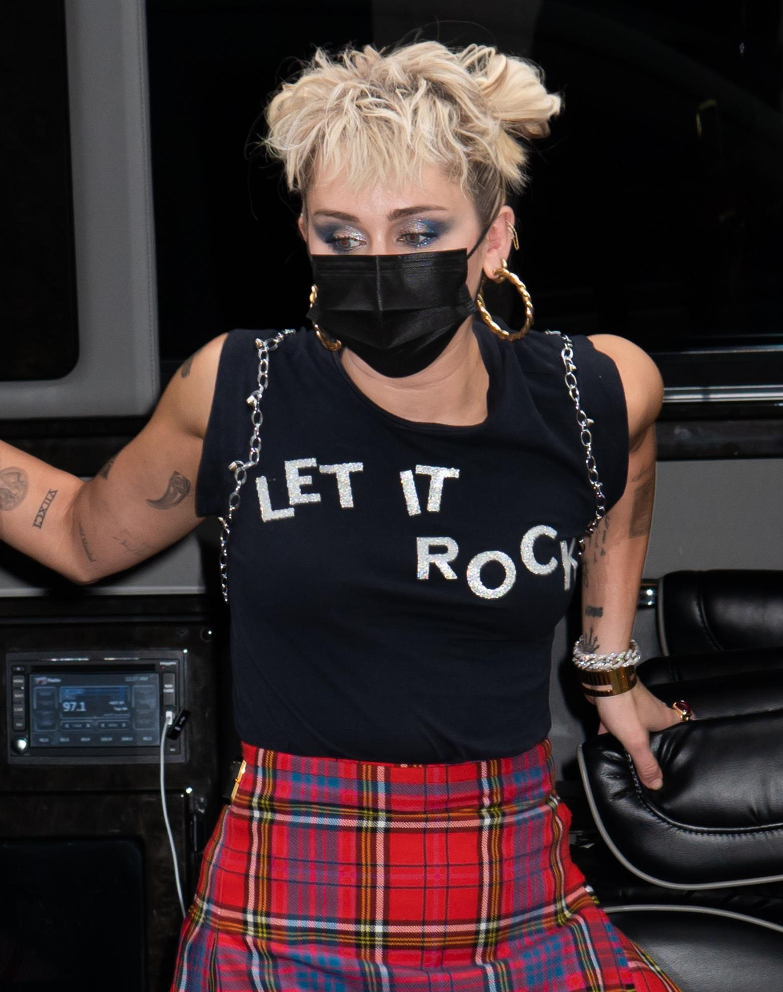 Miley Cyrus wears smokey eye-makeup with her blonde hair in messy pigtail bun