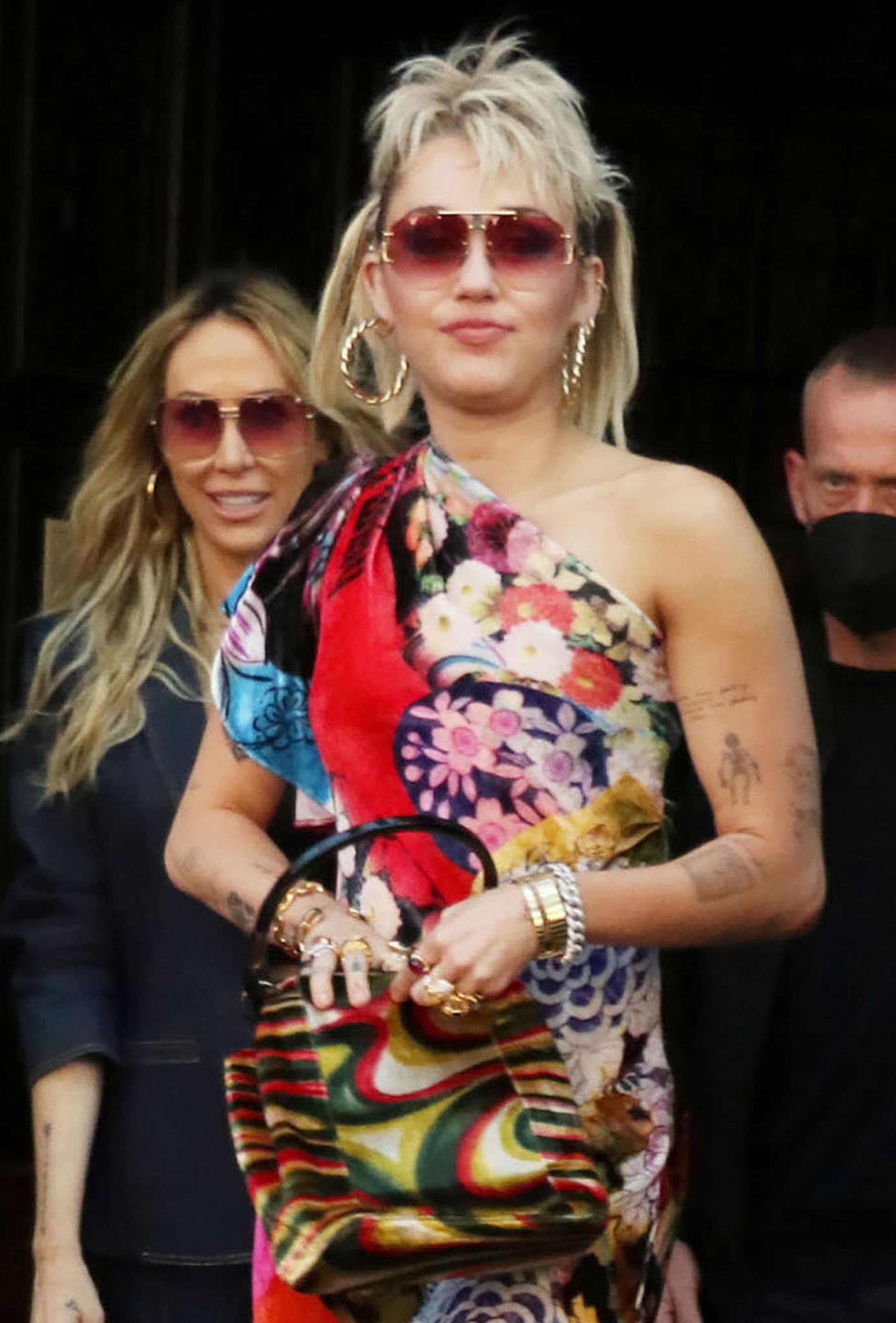 Miley Cyrus continues with her '70s look with Gucci Psychedelic bag, blonde mullet pigtails, and Celine pink sunglasses