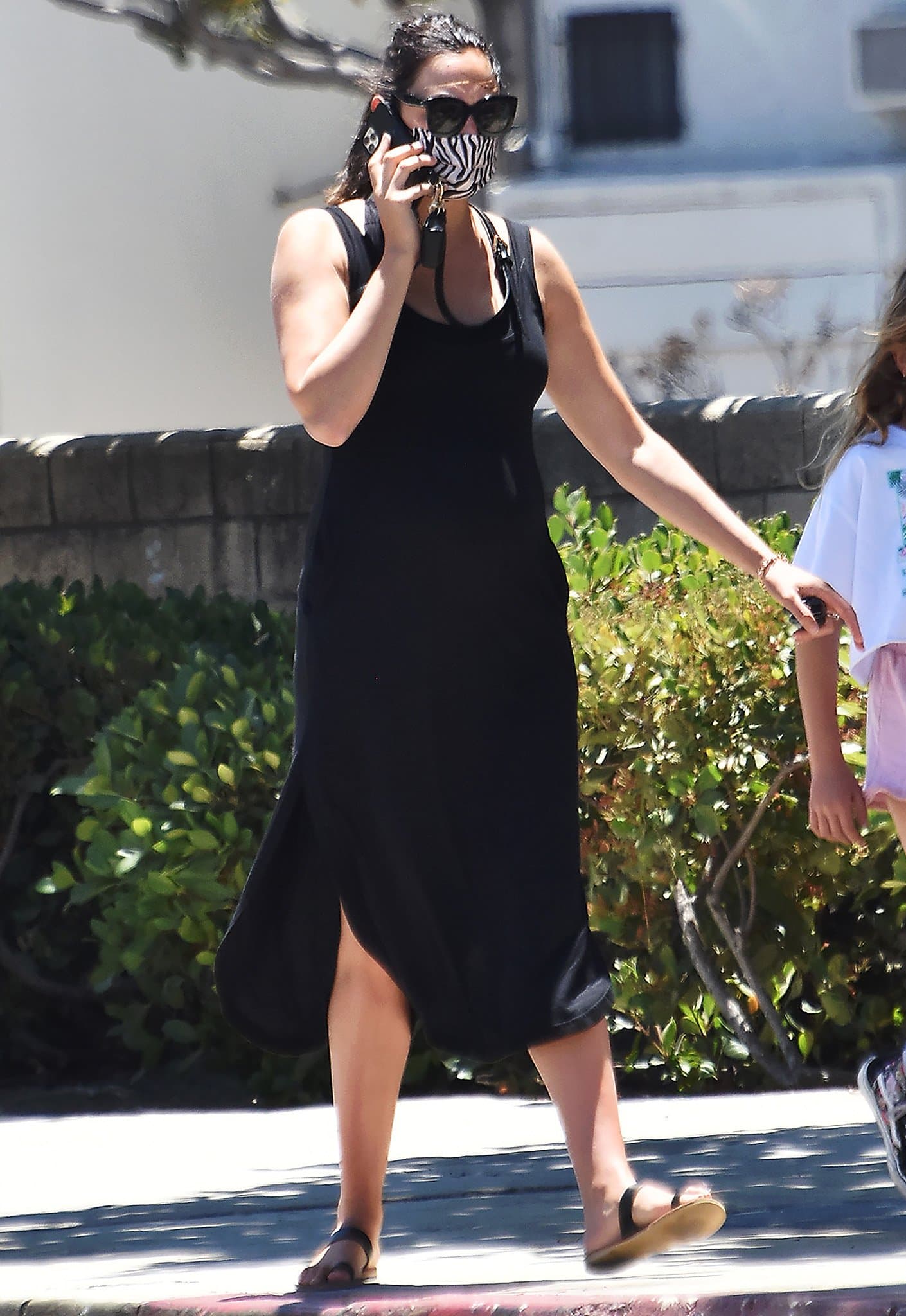 Gal Gadot highlights her baby bump in a form-fitting black midi dress