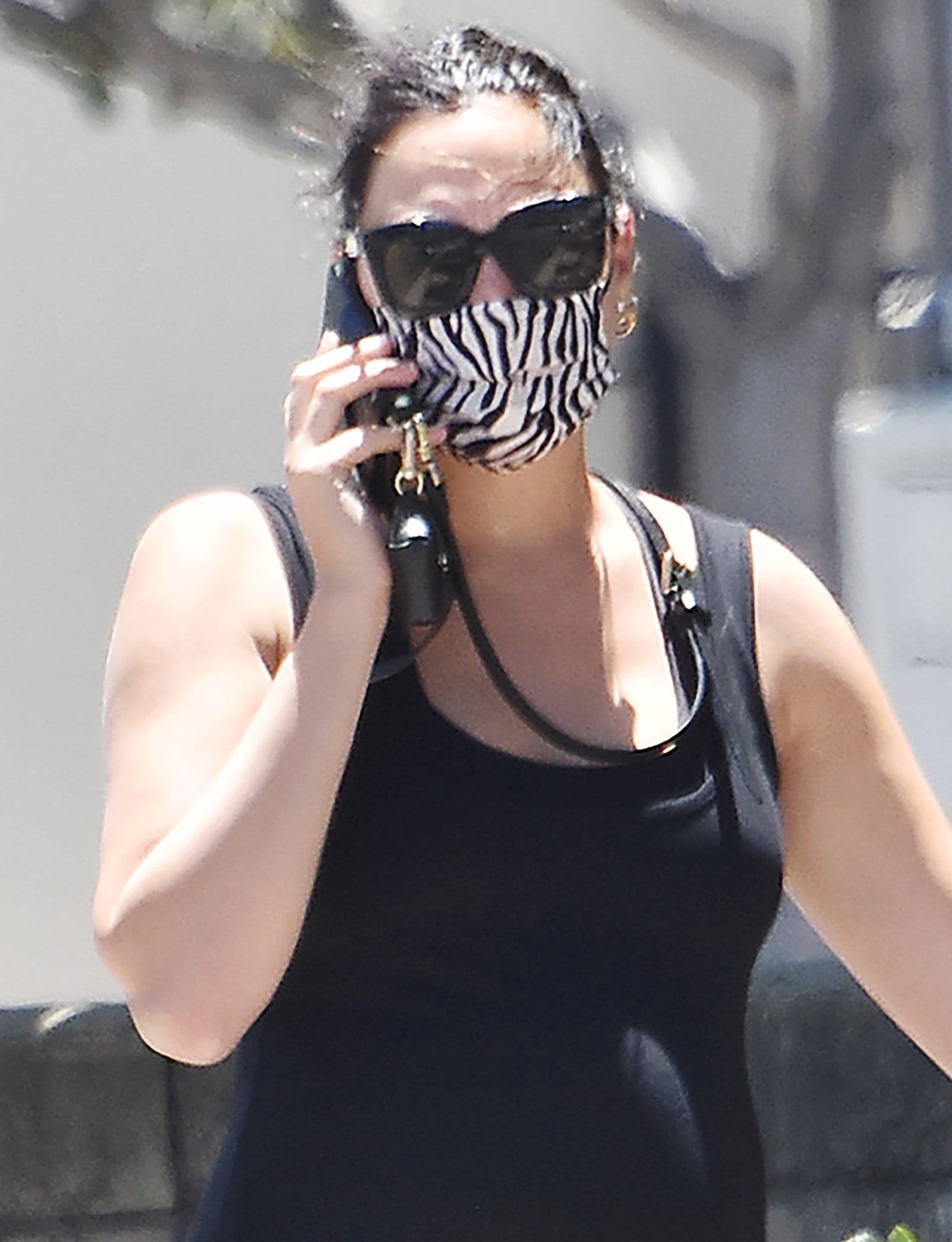 Gal Gadot ties her hair into a loose ponytail and stays low-key with black sunnies and a zebra-print face mask