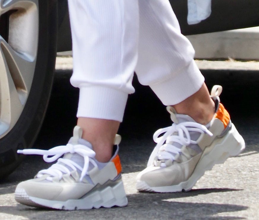 Hilary Duff steps out in Pierre Hardy Trek Comet sneakers, featuring a chunky ridged sole, tubular laces, and contrasting beige and orange accents for a sporty yet stylish look