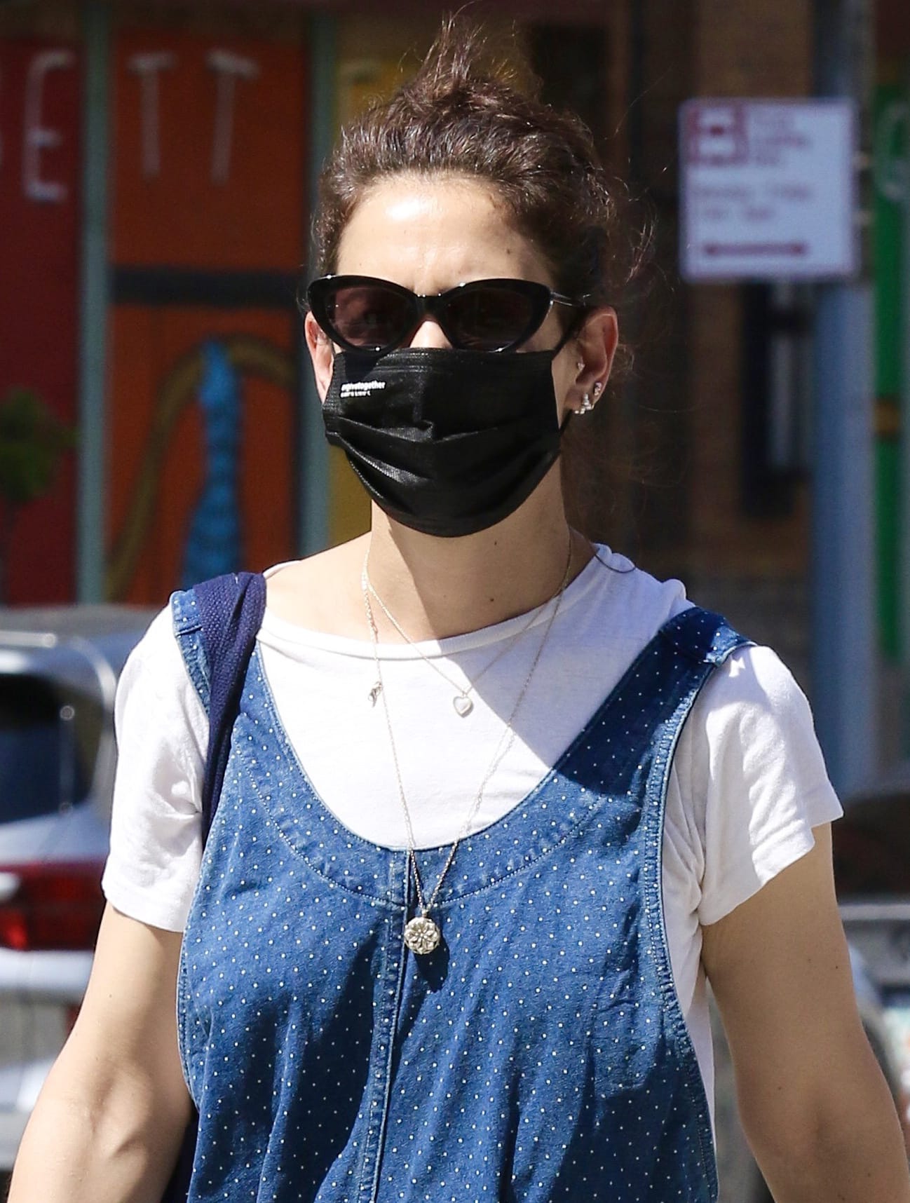 Katie Holmes pulls her naturally wavy tresses up into a messy bun and shields her eyes behind a pair of cat-eye sunglasses