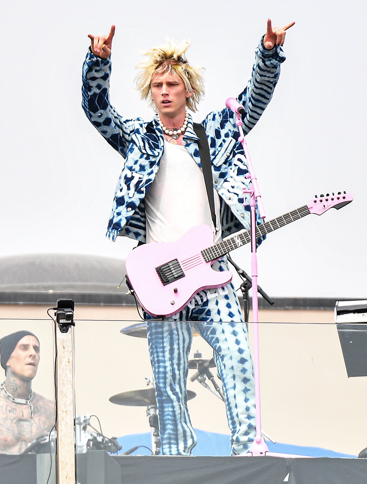 Machine Gun Kelly wears blue and white tie-dye-style jacket and matching pants