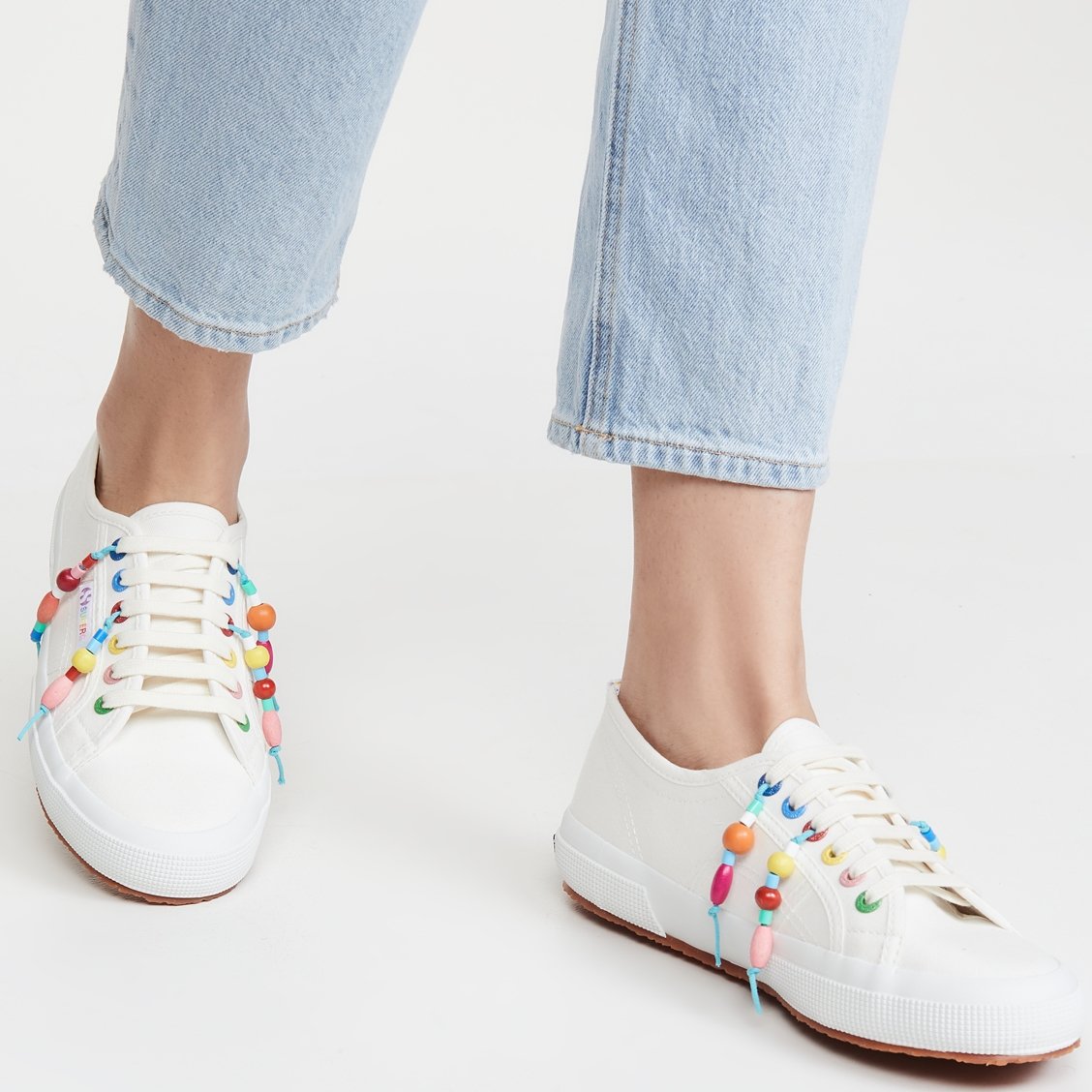 White Mira Mikati x Superga sneakers with multicolored grommets and beaded tassels for a carefree off-duty loo