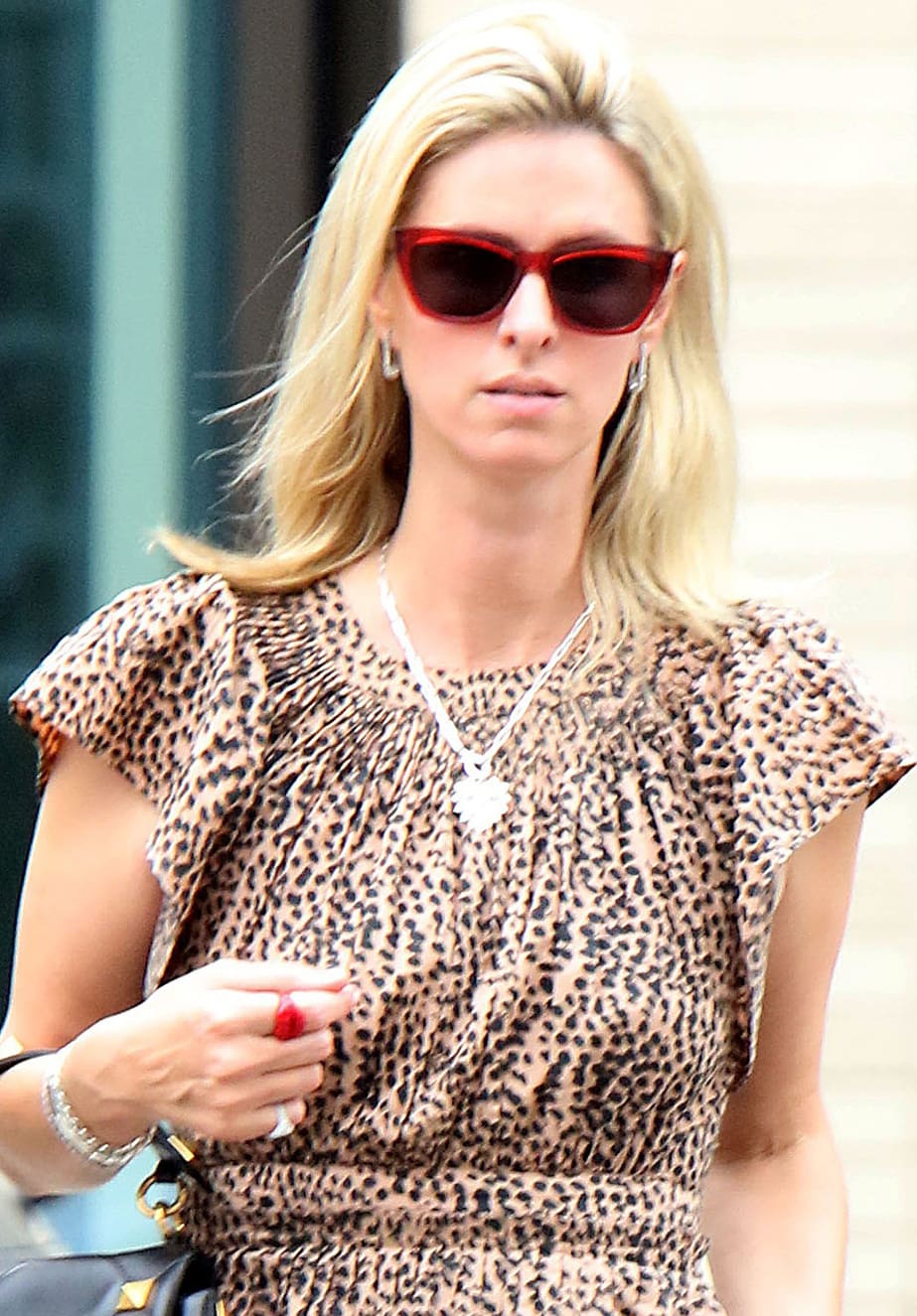 Nicky Hilton styles her look with red-framed sunglasses, minimal makeup, and loose tresses