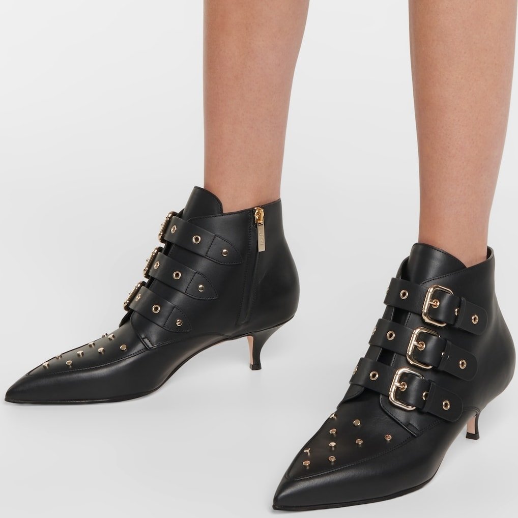 These ankle boots are made from supple calfskin leather and feature an array of studs and buckle straps along the tongues and piercing point toes