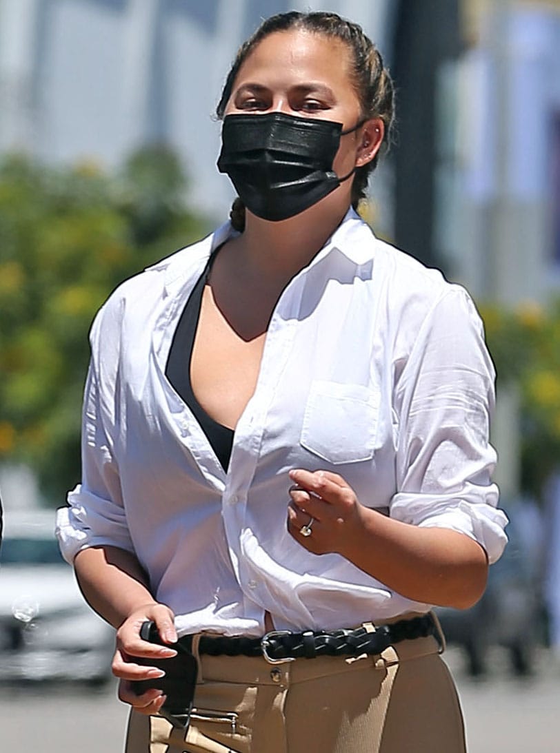 Chrissy Teigen wears a face mask and styles her hair in French braid