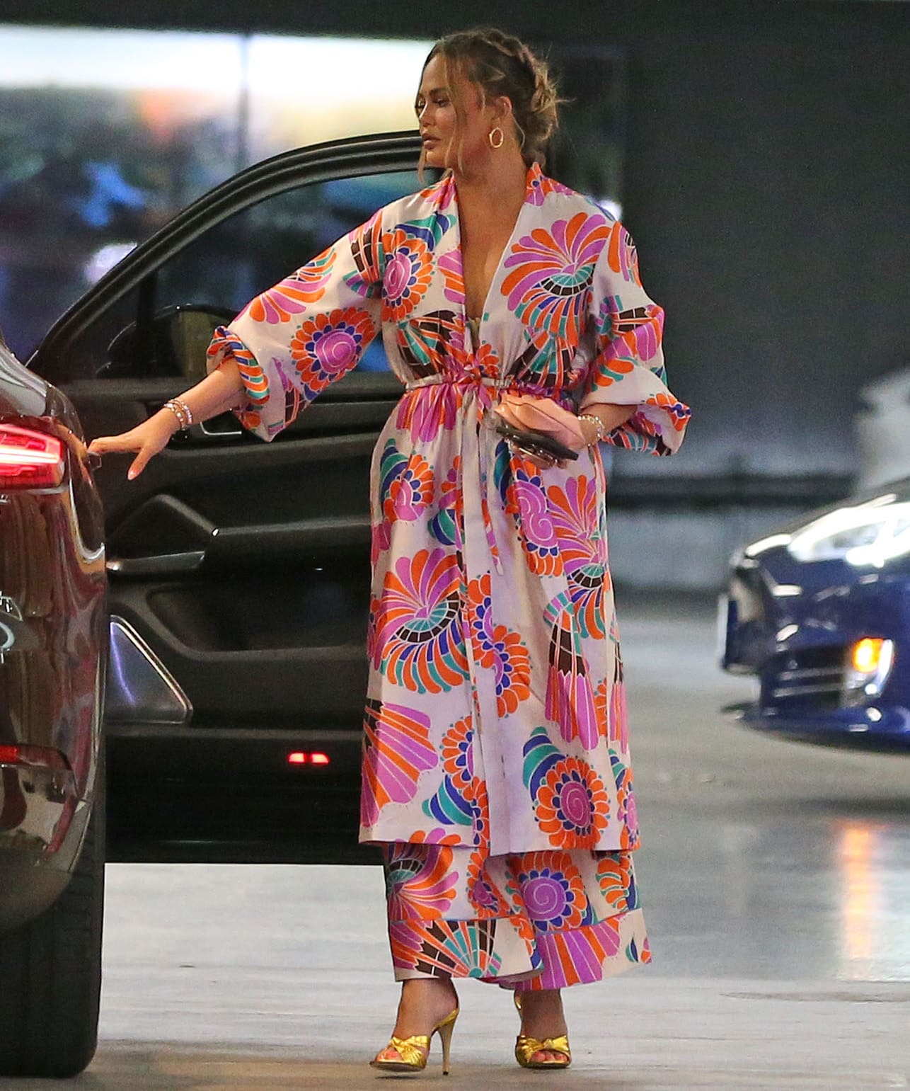 Chrissy Teigen opts for her signature printed silky robe with matching wide-leg pants for the family lunch