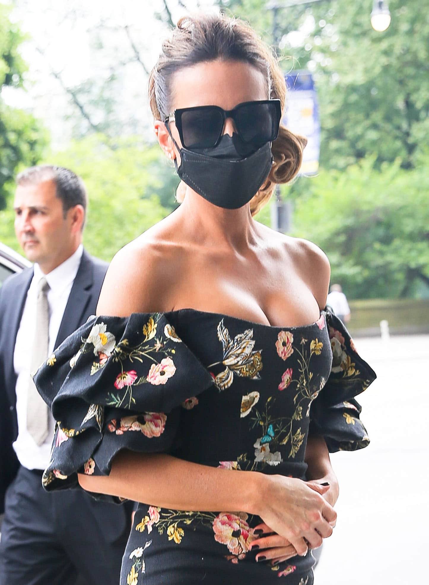 Kate Beckinsale accessorizes with stud earrings, square-framed sunglasses, and a black face mask