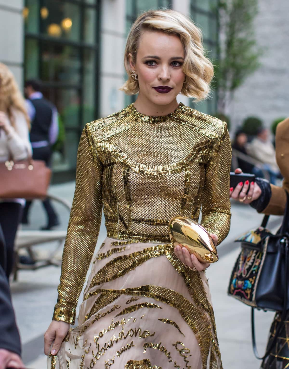 Rachel McAdams wears a gold mesh Valentino dress and dark purple lip as she makes her way to the Met Gala