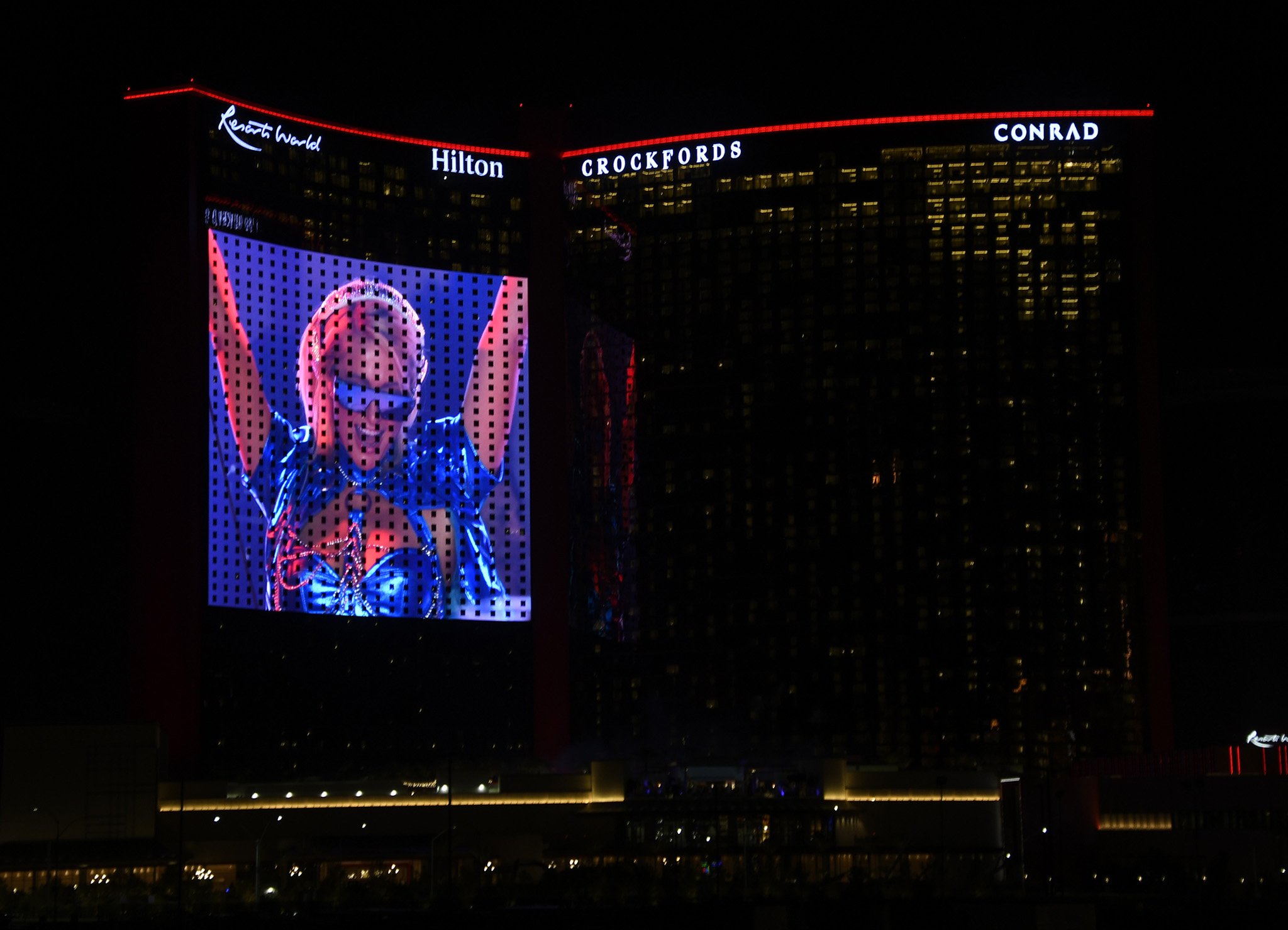 Paris Hilton is seen DJing on the big screen display during the grand opening of Hilton Resorts World Las Vegas on June 24, 2021