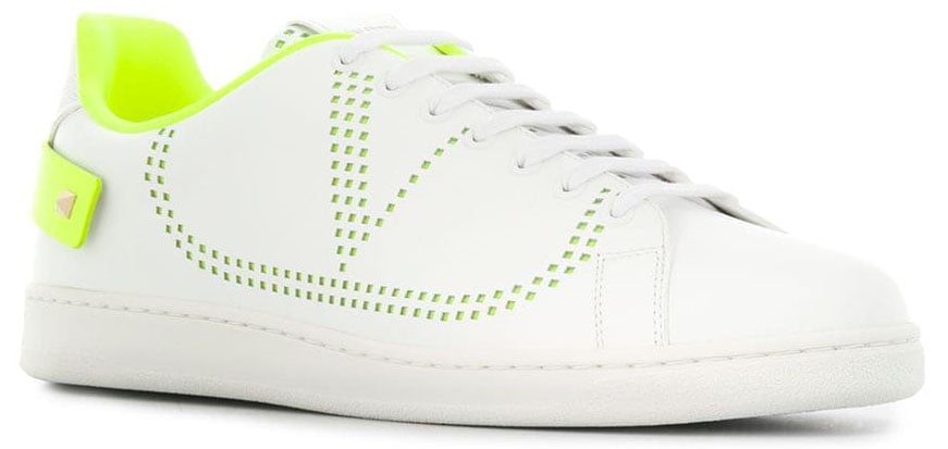 Neon accents with V logo and Rockstud-embellished heel straps detail the classic white tennis shoe silhouette