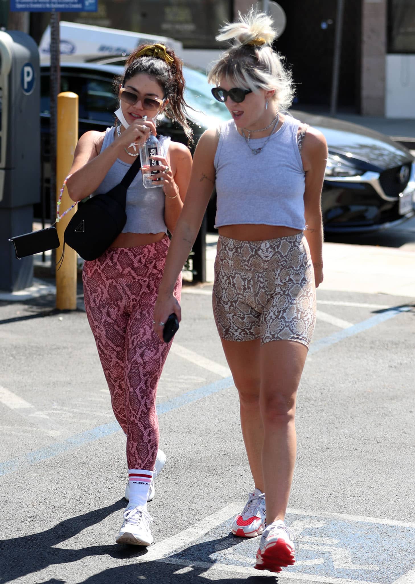 Vanessa Hudgens and best friend GG Magree coordinate in a gray cropped tank top and snakeskin bottoms while leaving Dogpound gym