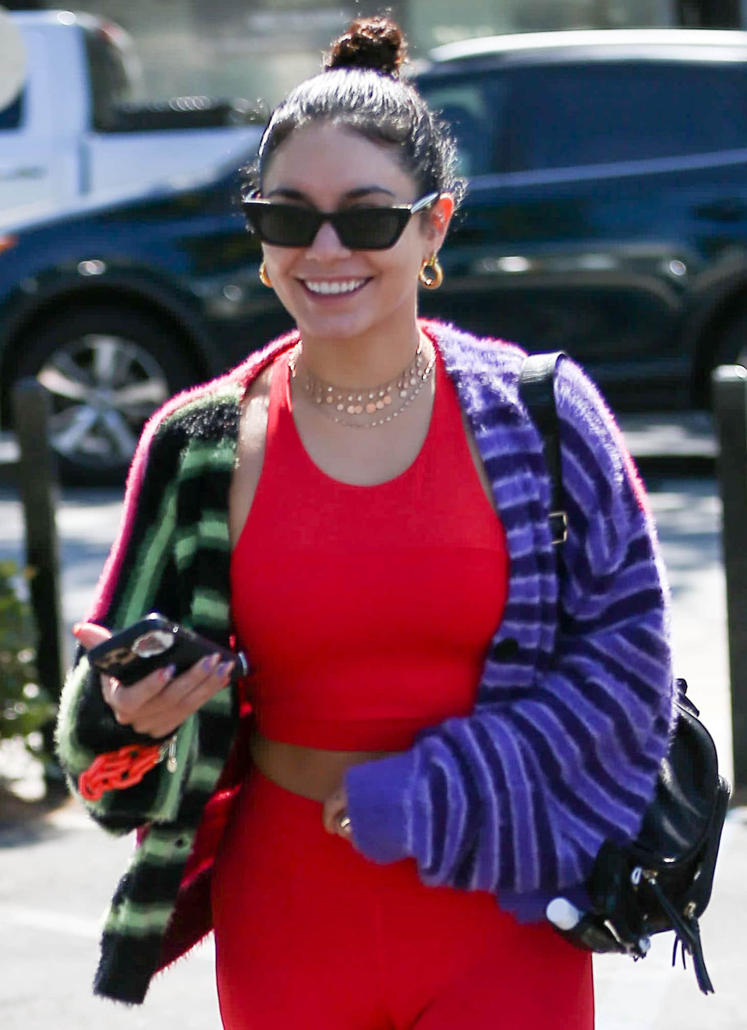 Vanessa Hudgens pulls her hair up into a tight high bun and covers her eyes with black sunglasses