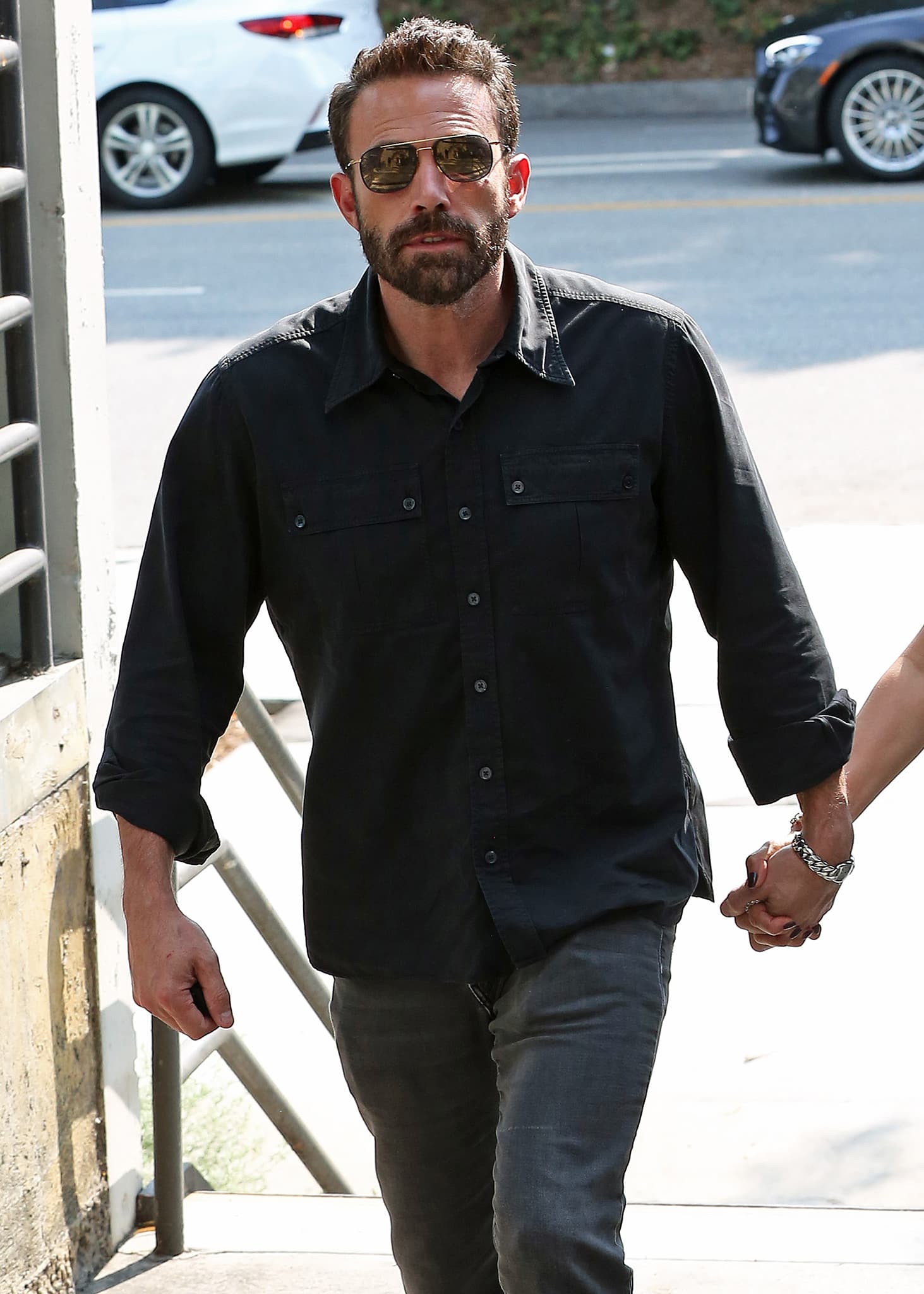 Ben Affleck looks handsome in his black shirt, gray pants, and aviator sunglasses