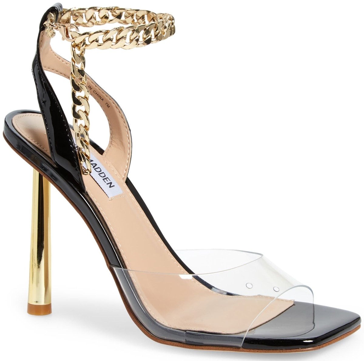 A chunky chain wraps around the ankle of a stunning black/clear sandal from Steve Madden set on a towering golden heel