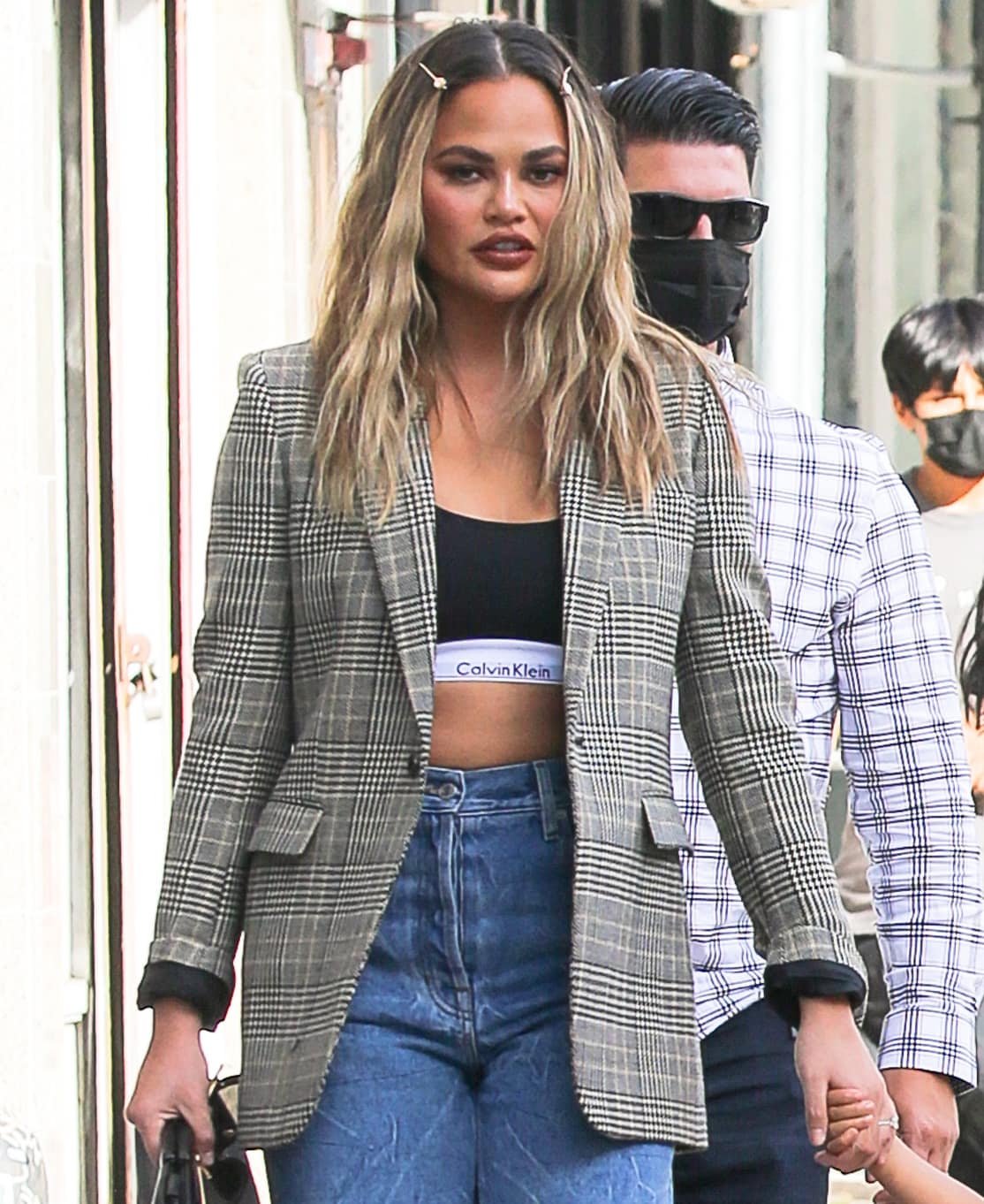 Chrissy Teigen continues the '90s vibe of her look with center parted loose waves secured with two pins
