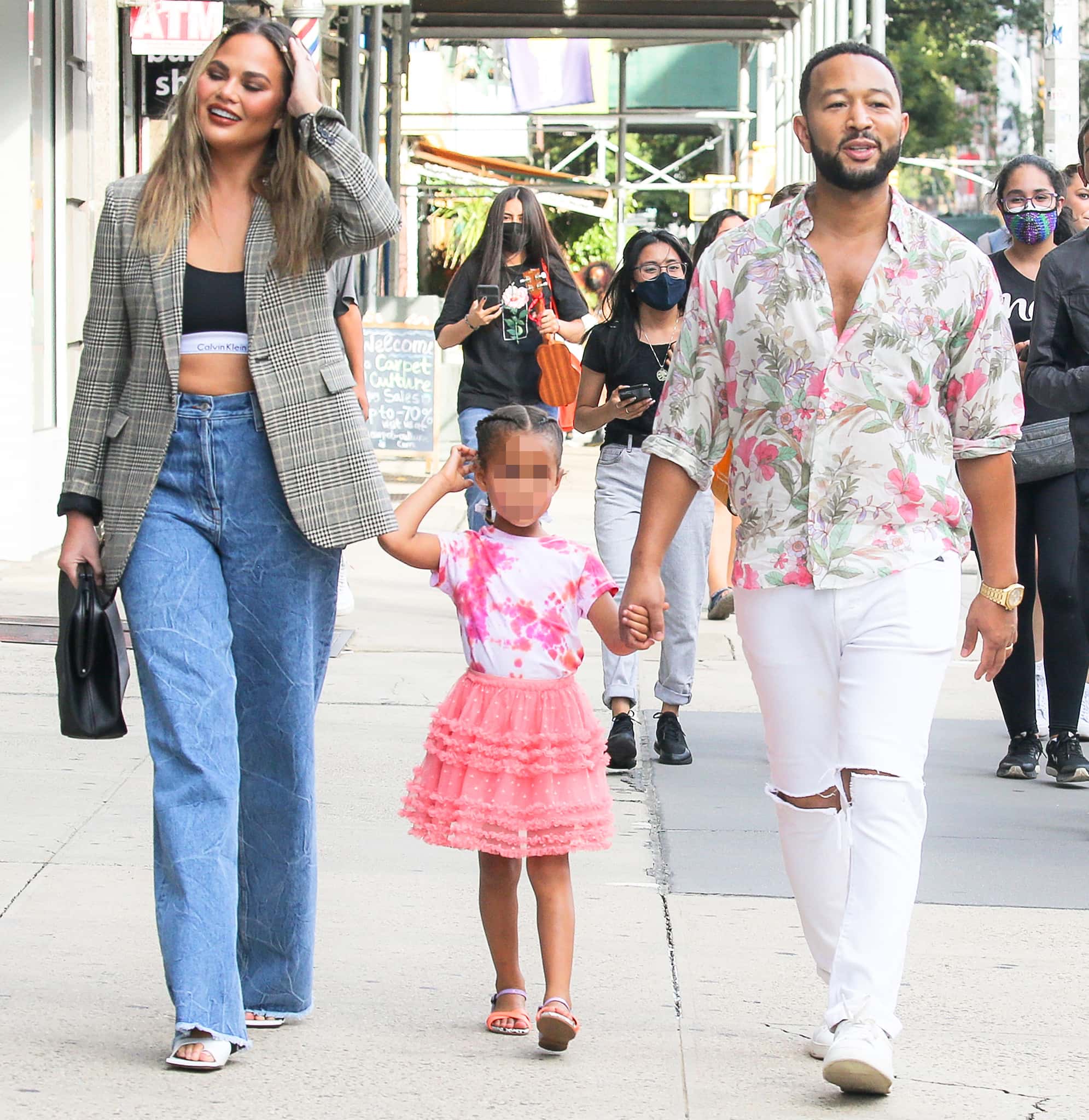 Chrissy Teigen and John Legend hold hands with daughter Luna while strolling in New York City on August 19, 2021