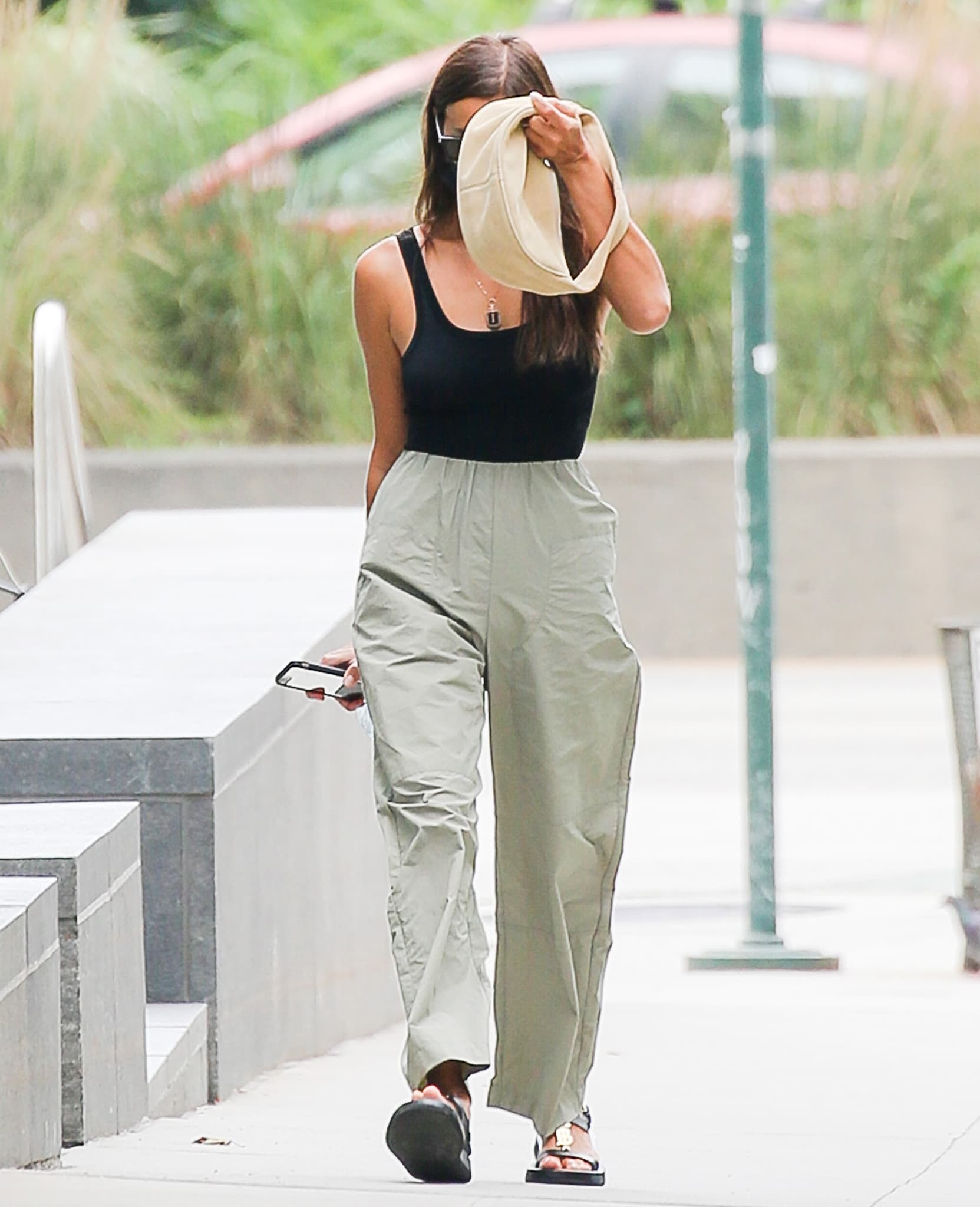 Irina Shayk shows off her model figure in a black bodysuit with olive green loose pants