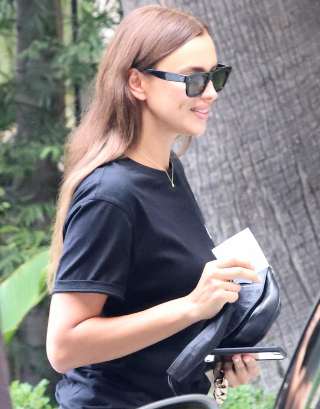 Irina Shayk keeps things simple with barely-there makeup and hides her eyes behind a pair of Celine sunnies