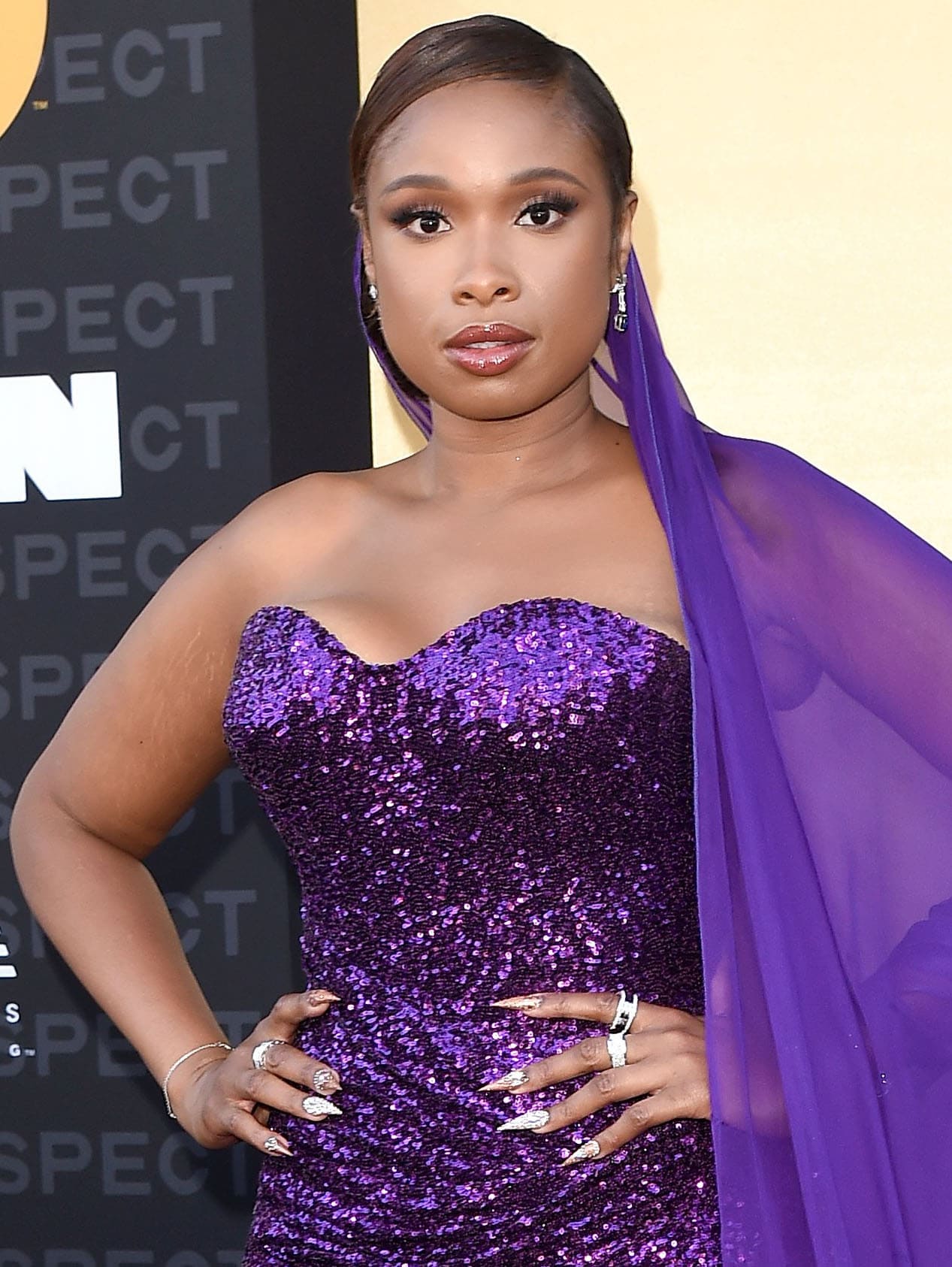 Jennifer Hudson styles her hair in a neat side-parted bun and wears neutral makeup with pink smokey eyeshadow