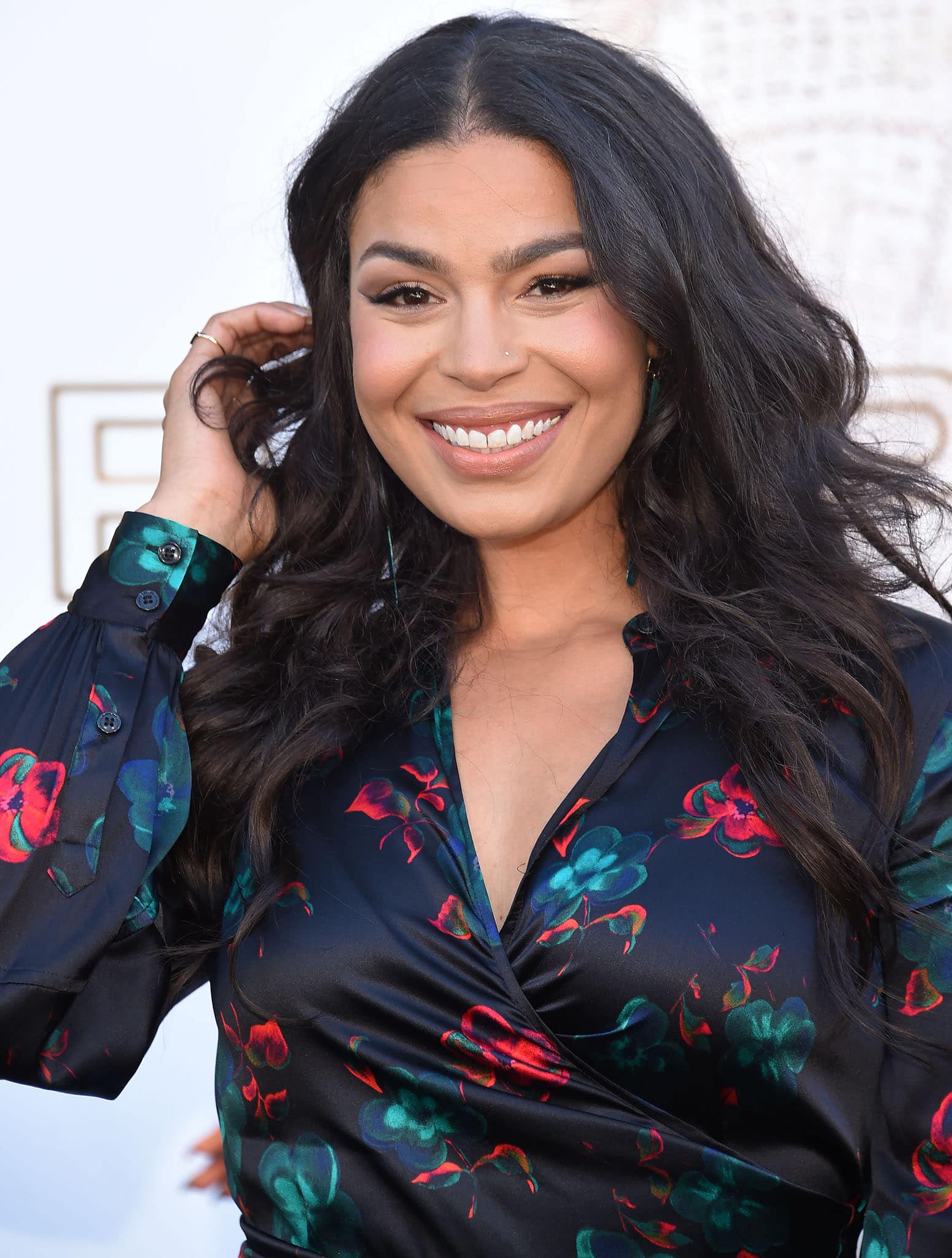 Jordin Sparks wears her long tresses in loose waves and highlights her features with nude makeup