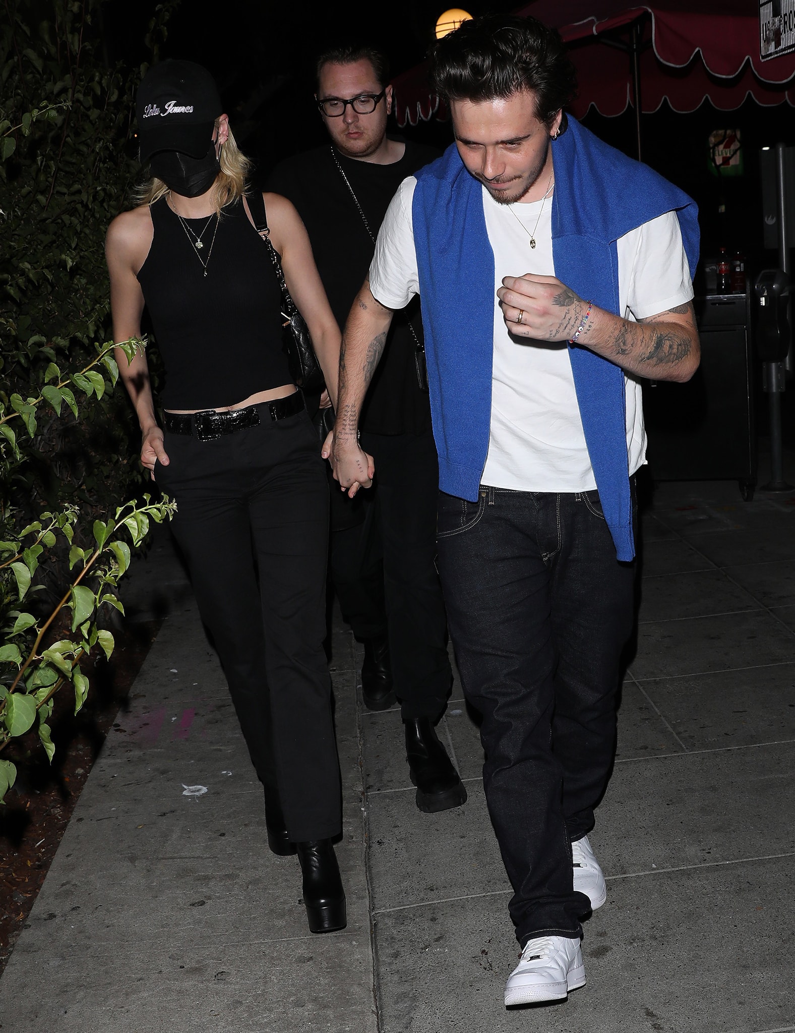 Nicola Peltz flashes her belly button in Brandy Melville Natasha fitted tank top and Dickies black pants