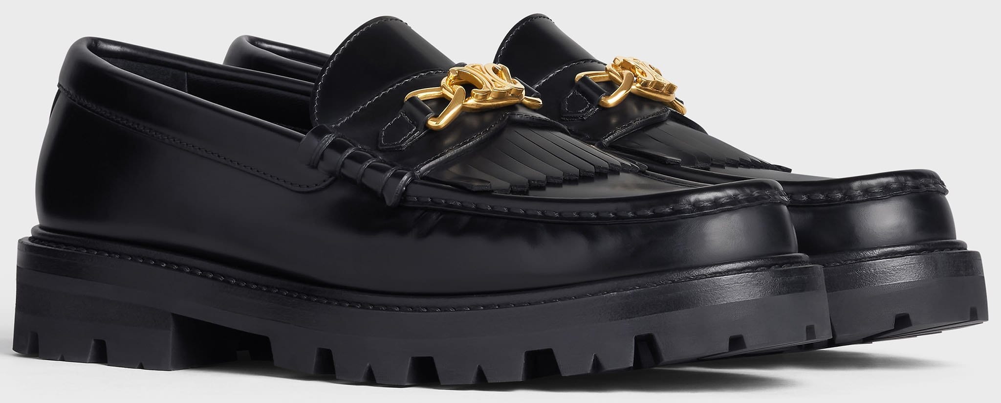 The Celine Margaret chunky loafers feature Triomphe gold chain, fringes, and rubber lug outsoles