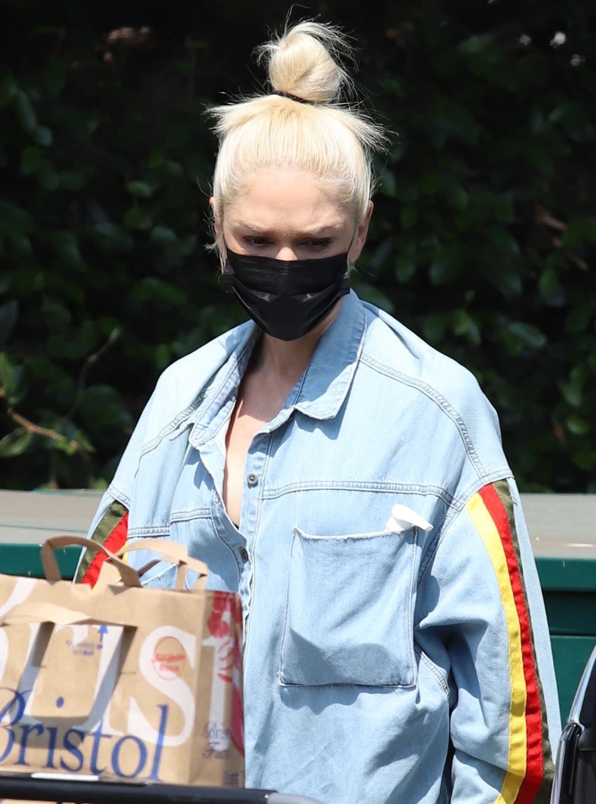 Gwen Stefani wears a casual top knot with a black face mask