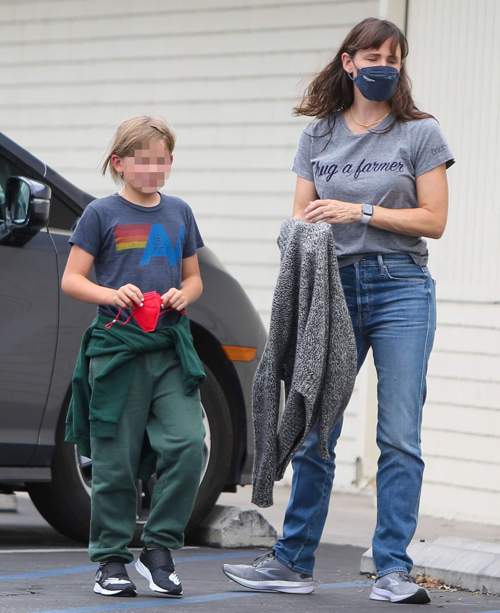 Jennifer Garner's son, Sam, wears a navy tee with green jogging pants and New Balance sneakers