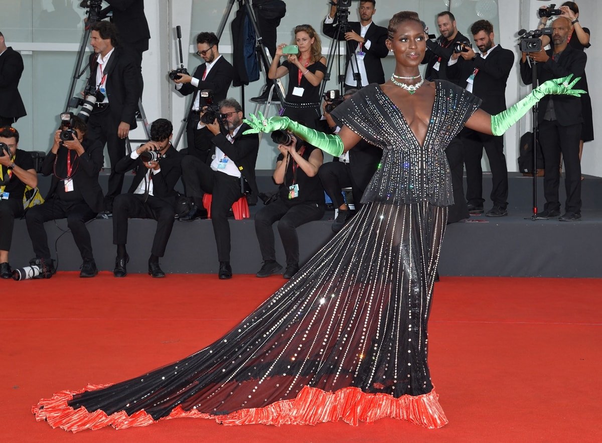 Jodie Turner-Smith in a glittering Gucci gown with bright green opera-length gloves and emerald jewelry at the Netflix film "White Noise" and opening ceremony red carpet at the 79th Venice International Film Festival