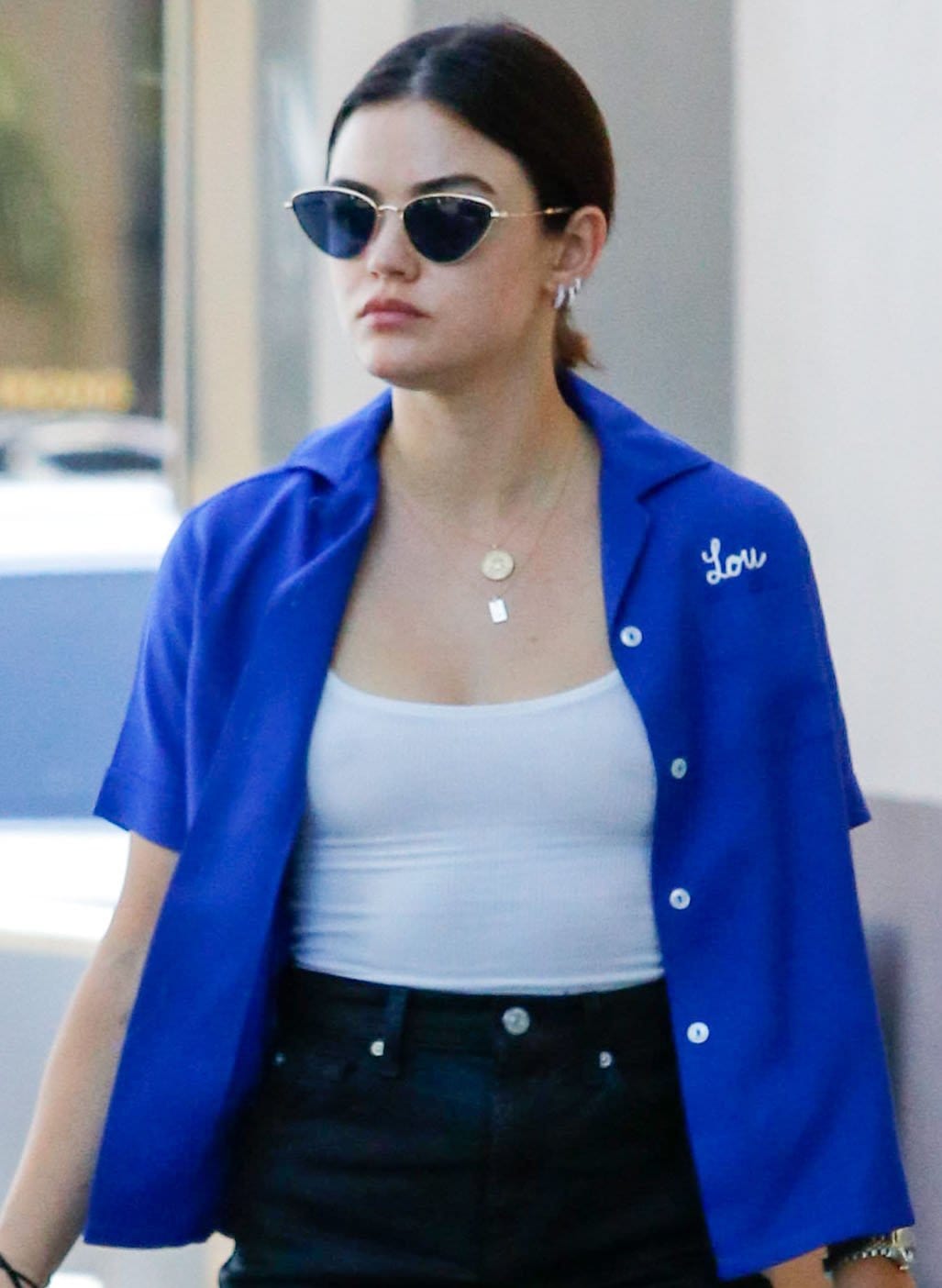 Lucy Hale pulls her hair back into a low ponytail and wears minimal makeup with Paradigm cat-eye sunglasses