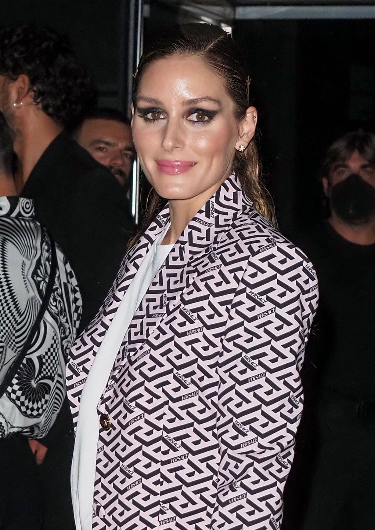 Olivia Palermo wears a slicked-back ponytail with smokey cat-eye makeup and pink lipstick