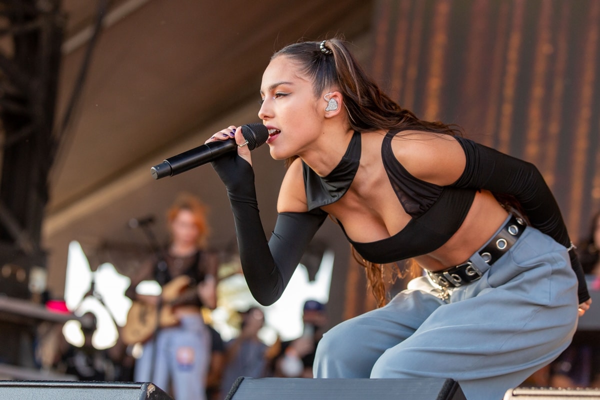 Olivia Rodrigo in blue and grey trousers from Eytys and a Cup of Stars Huxley crop blouse performs on day 2 of the 2021 iHeartRadio Music Festival