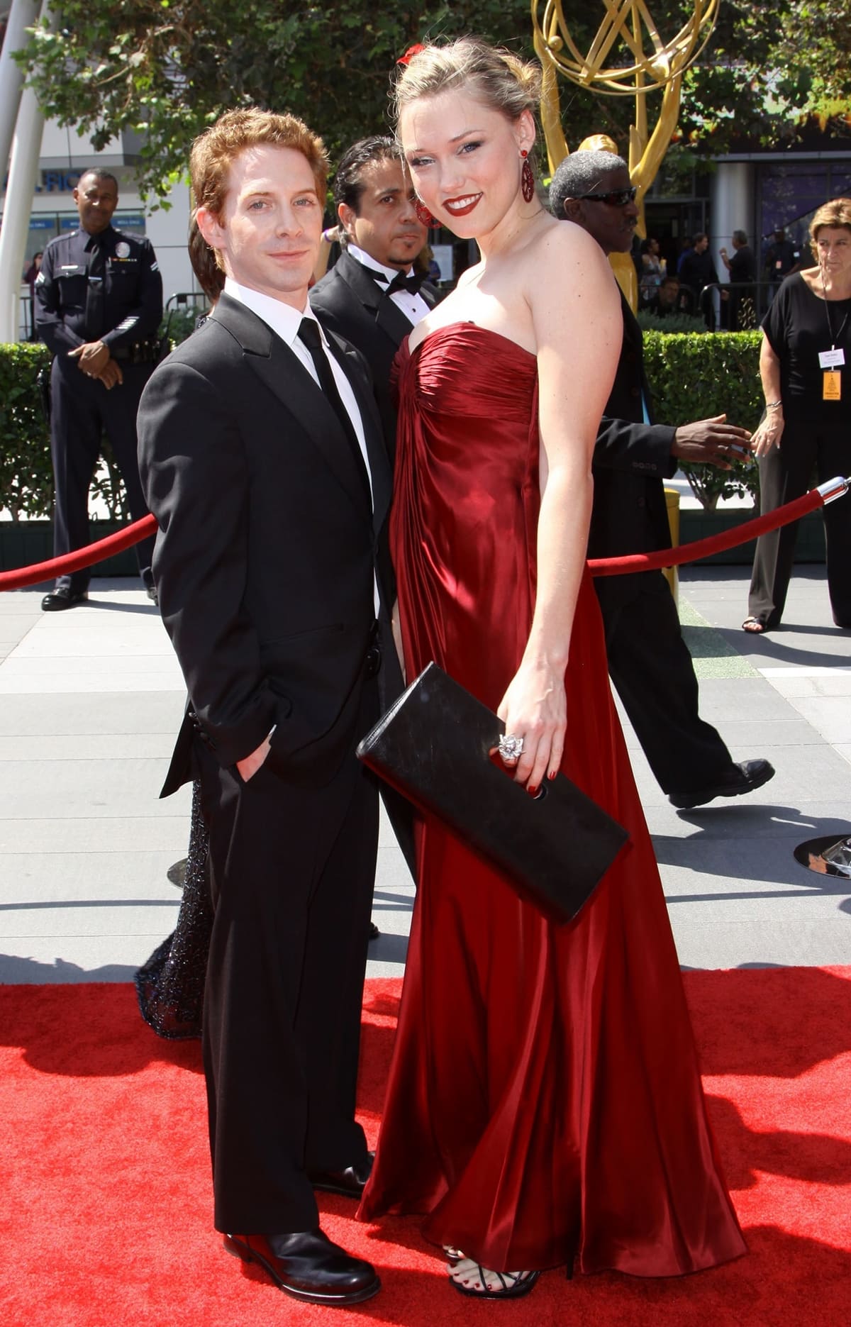 Clare Grant dazzles in a deep red strapless gown with matching earrings, while Seth Green looks sharp in a classic black suit
