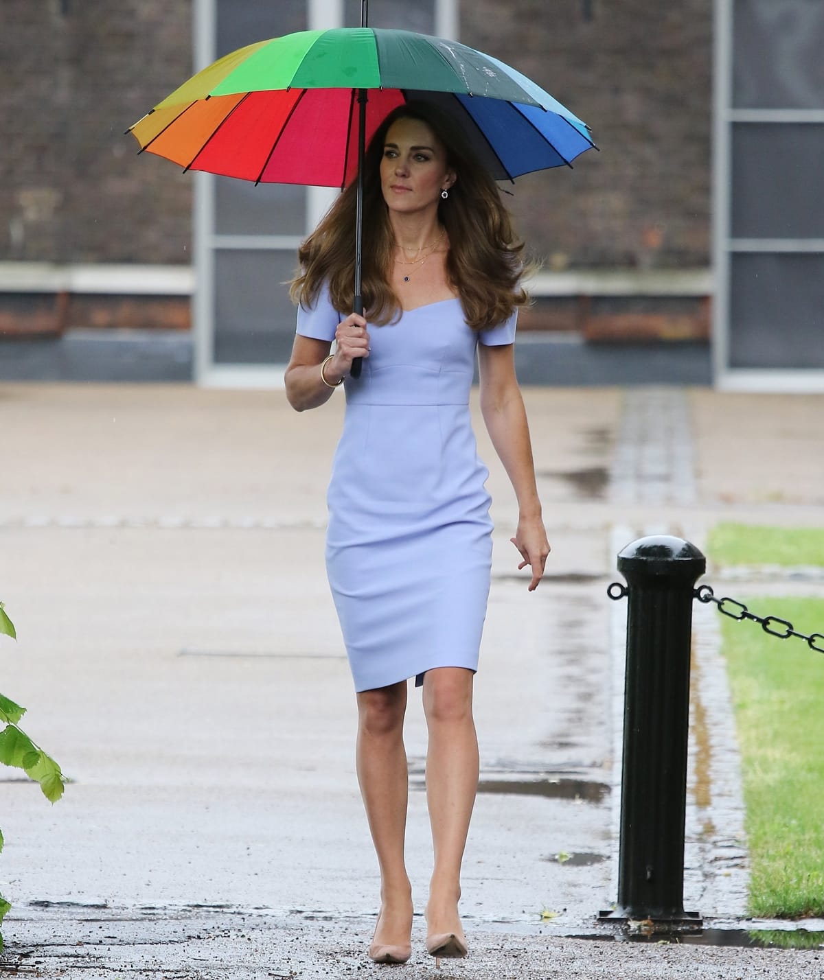 The Duchess of Cambridge in a pale blue shift dress from the Royal Ascot x L.K.B collection shelters from the rain under an umbrella as she arrives at Kensington Palace