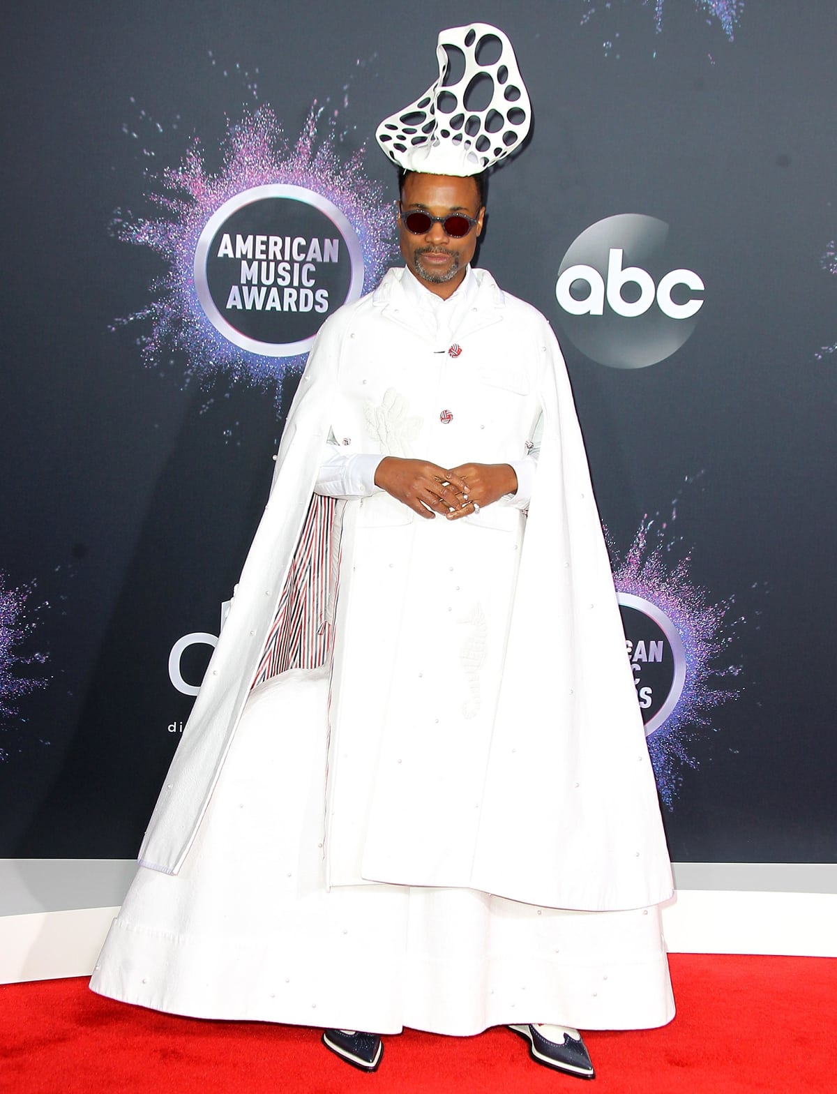 Billy Porter in a white outfit from Thom Browne’s Spring 2020 collection and cutout headpiece from Stephen Jones Millinery at the 47th American Music Awards