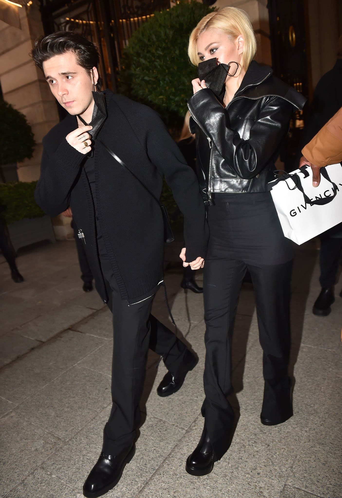 Brooklyn Beckham and Nicola Peltz wear coordinating black looks, with Nicola in a black leather biker jacket and Brooklyn in a rib-knit cardigan